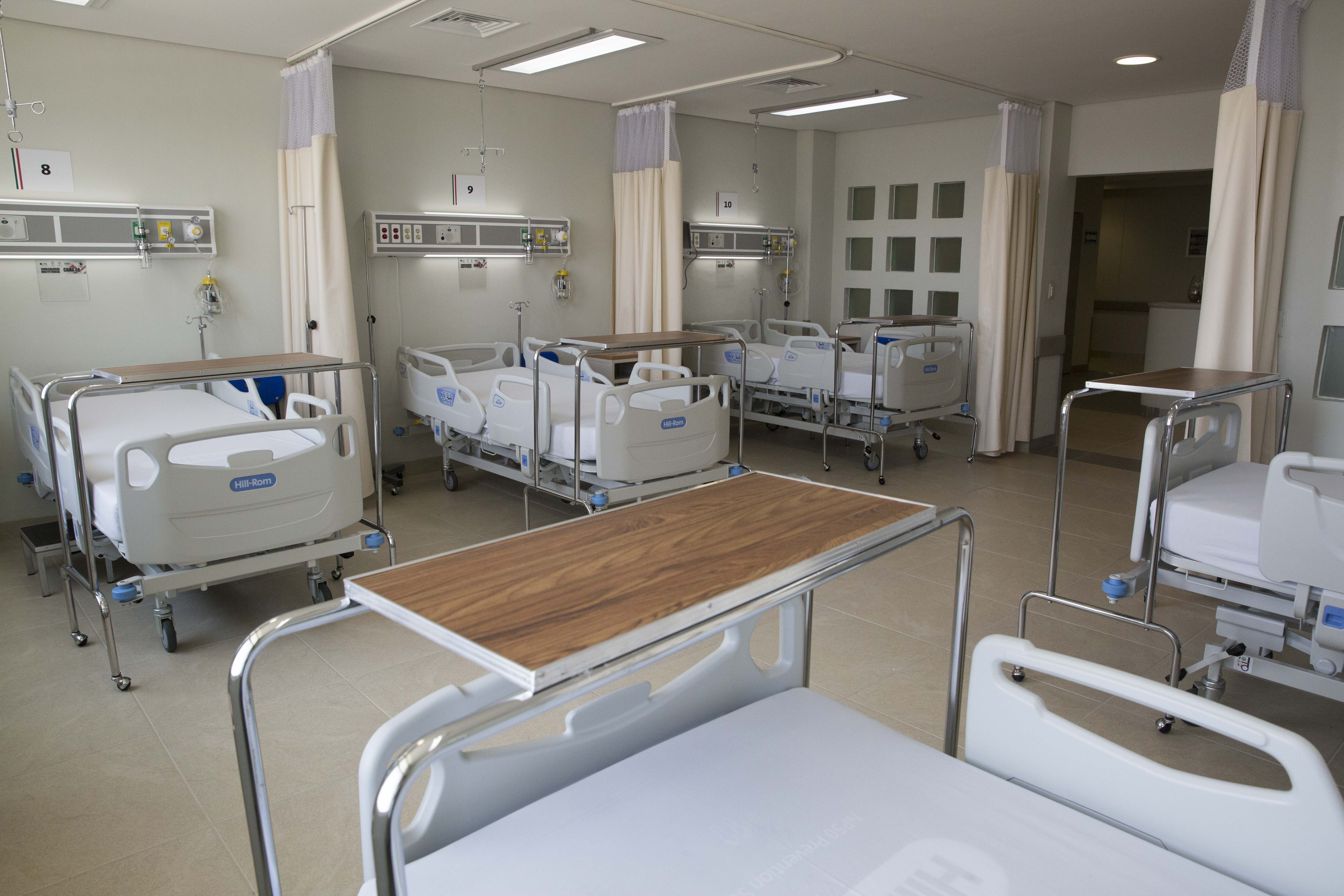 Ala de hospital com diversas camas e equipamentos